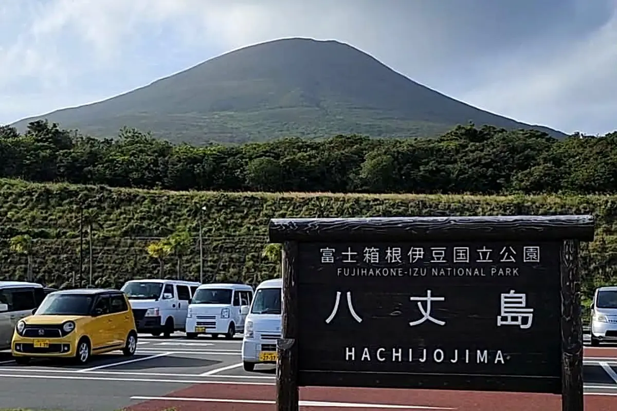 Le panneau d'entrée de Hachijō-jima, avec le volcan de l'île en arrière-plan