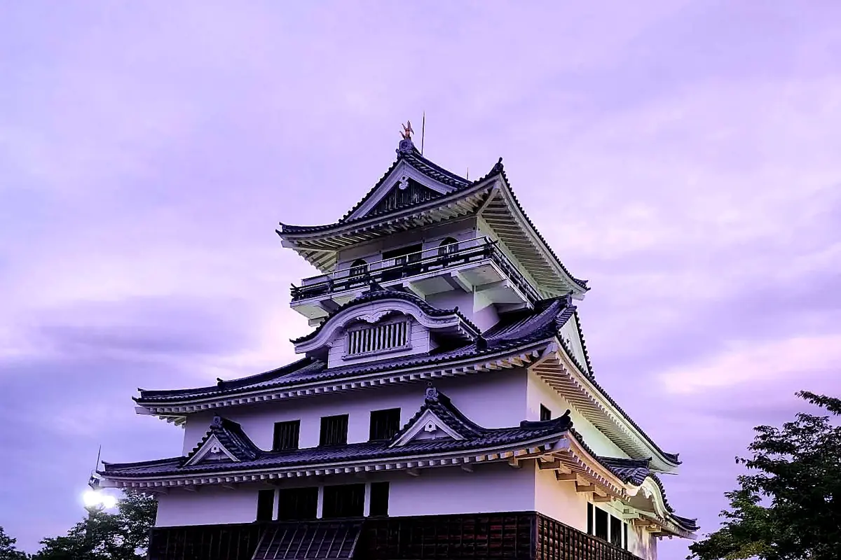 Un château japonais traditionnel se détachant sur un ciel violet au crépuscule